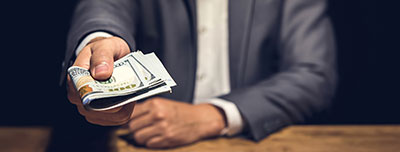 Give to Get, businessman handing over a stack of Federal Reserve notes